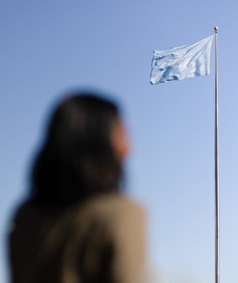 Individual looking at the United Nations flag.